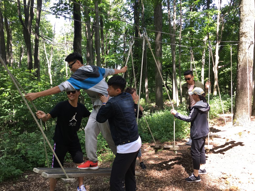 Students helping each walk on a rope_obstacle course Open Gallery